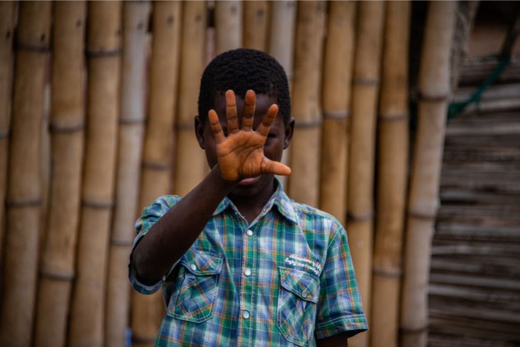 Boy with his hand in front of face