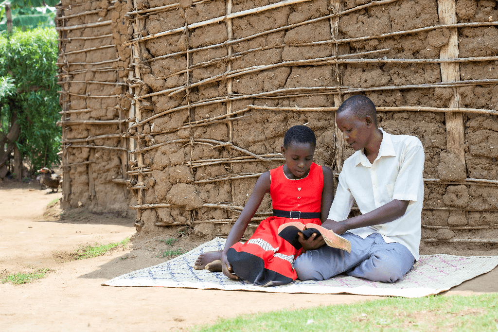 Lynet and her father are outside reading the Bible together.