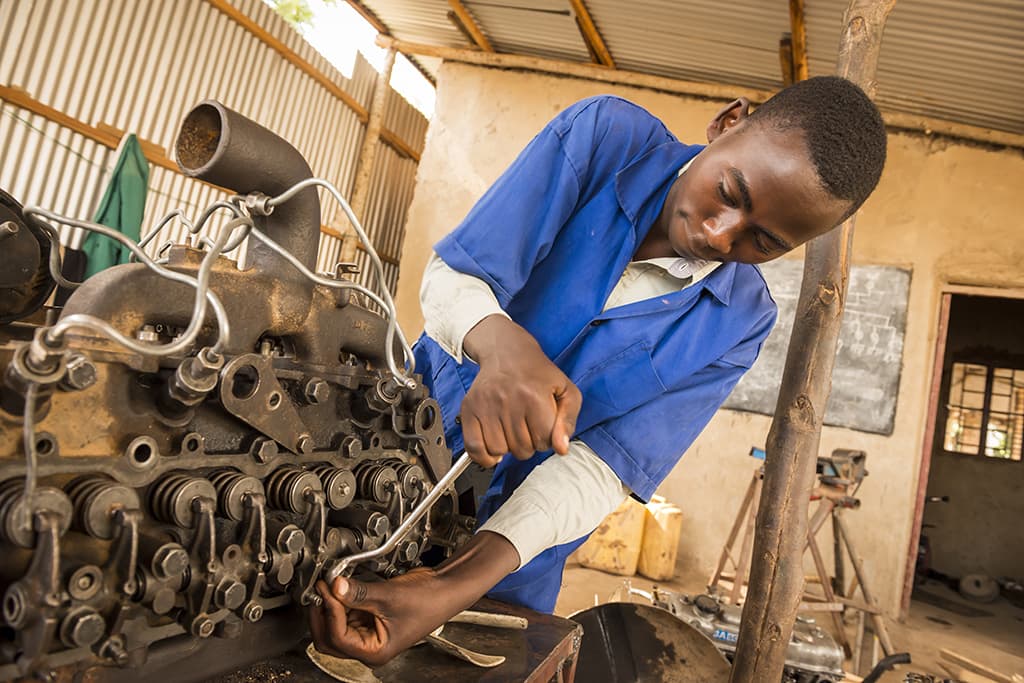 A boy fixing a car engine
