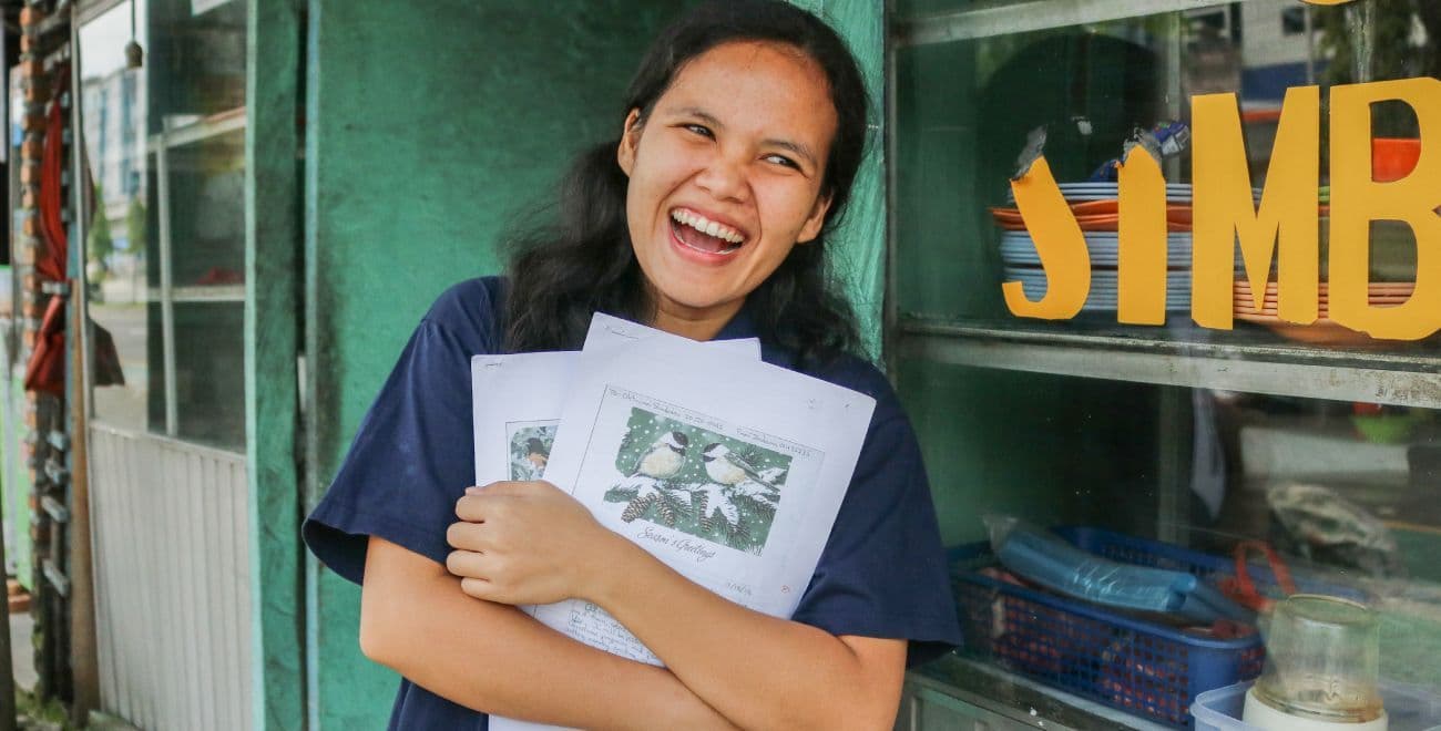 Ani smiles and holds letters f