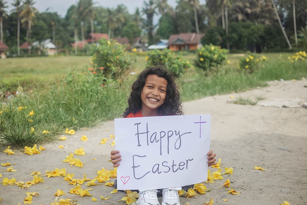 A girl from Indonesia holding a handdrawn sign