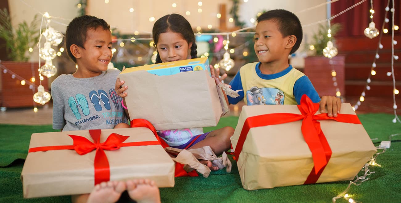 a group of children with gifts wrapped in brown paper