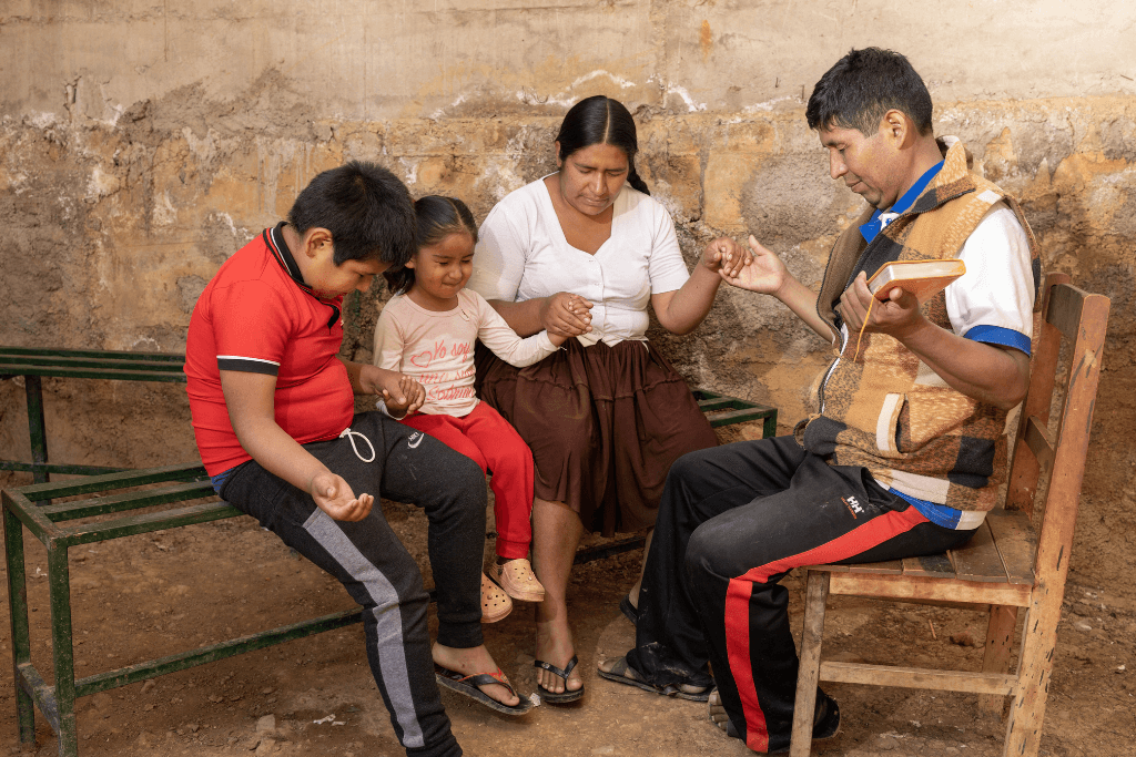 Mario and Neisa pray with their family
