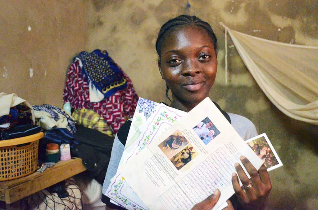 Alcha from Burkina Faso holding letters from her sponsor