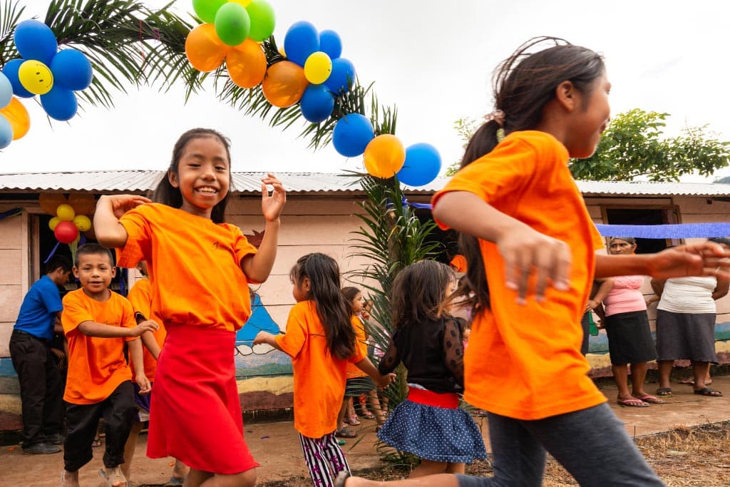Children running through a balloon archway in Mexico