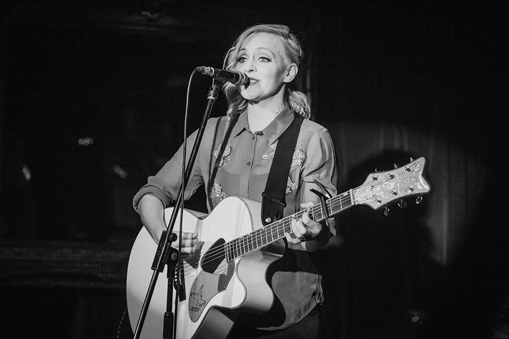 Philippa Hanna - singing with guitar on stage