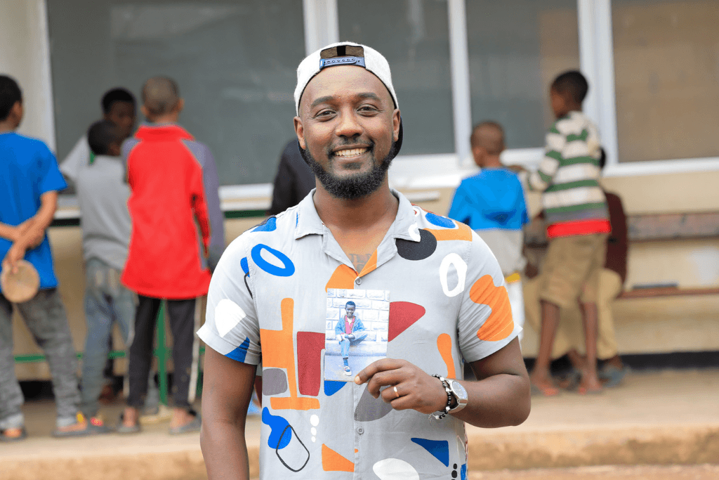 Kemi holding a photo of himself as a child