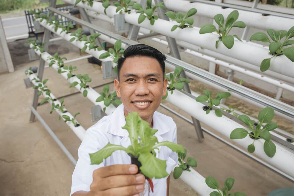 Fizky holding up produce from his hydroponic garden.