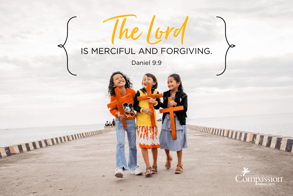 Three children walk together joyfully while to the top Daniel 9:9 is quoted, reminding us that the Lord is merciful and forgiving.