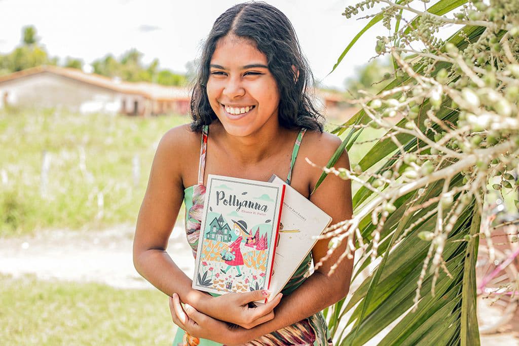 Ana Vitória holding her first two books.