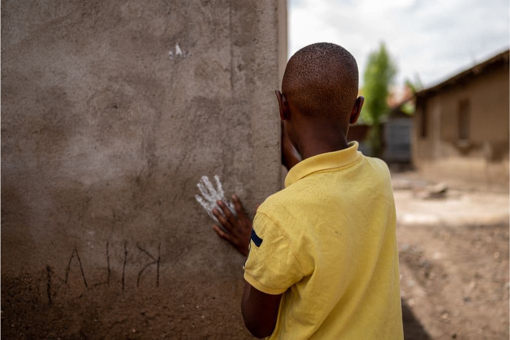 Boy standing next to wall